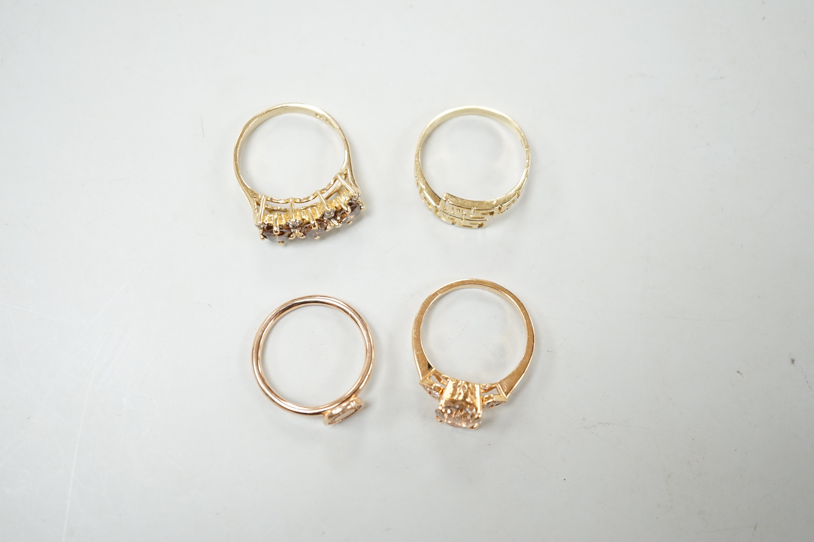 Three assorted modern 585 yellow metal and gem set rings, including two rose coloured and a 585 'Greek Key' ring, gross weight 11.1 grams.